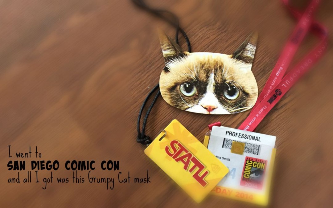 grumpy cat mask, nerdist and sdcc lanyards on wooden desk